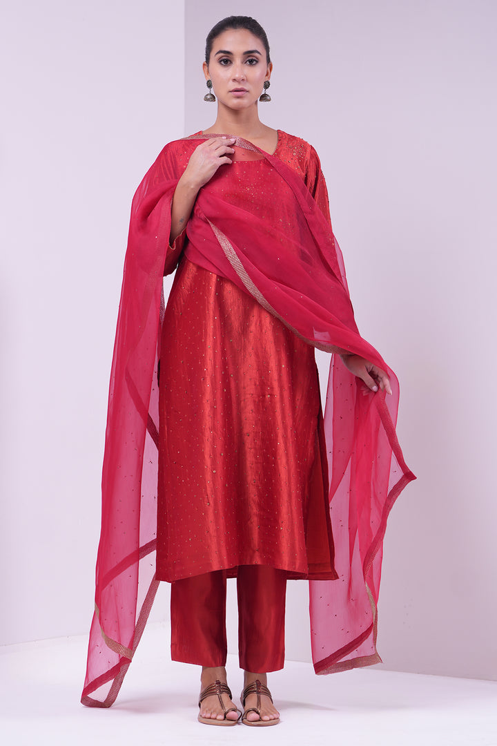 Woman wearing a red traditional outfit with a dupatta on a white background